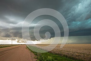 A wall cloud forms underneath a tornadic supercell thunderstorm on the plains.