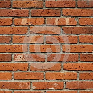 A wall composed of rectangular, reddish-brown bricks arranged in horizontal rows. photo