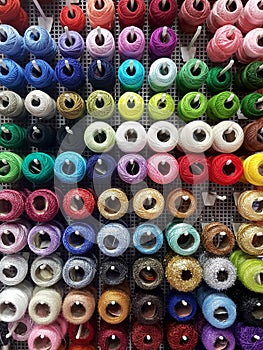 Wall of cotton reels, lots of colorful spools of thread displayed at the notions store, many sewing accessories for art and crafts