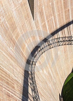 The wall of the dam with the shadow of the bridge on it