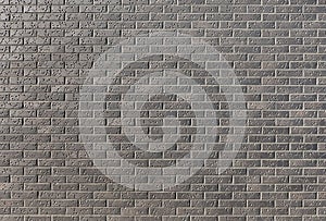 Wall from a dark brick with a pattern in a bright sunny day as a