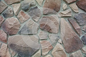 Texture - artificial decorative stone faÃÂ§ade. Decorative grey color rough stone wall background texture.