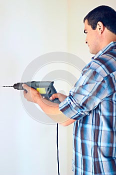 Wall drill, home and man with renovation, construction work or house improvement for maintenance, repair or builder