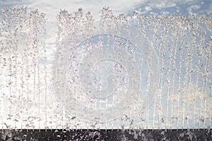 Wall of drops and trickles of water from the fountain photo