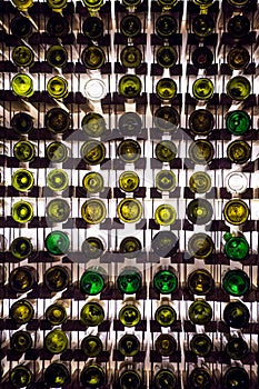 Wall of empty wine bottles. Empty wine bottles stacked-up on one another in pattern lit by the light coming from behind
