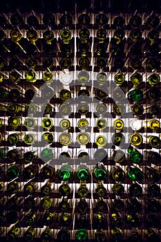 Wall of empty wine bottles. Empty wine bottles stacked-up on one another in pattern lit by the light coming from behind