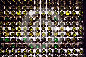 Wall of empty wine bottles. Empty wine bottles stacked-up on one another in pattern lit by the light coming from behind