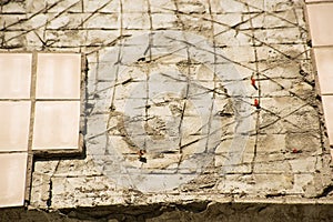 The wall of the facade of the building with fallen off beige tiles