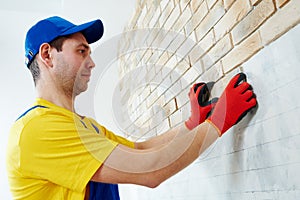 Wall facing work with brick by professional bricklayer worker