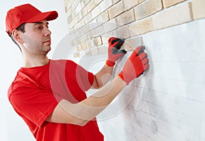 Wall facing work with brick by professional bricklayer worker