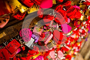 Wall full of red and pink love locks shaped as hearts