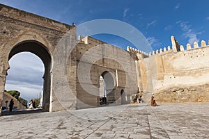 Old man in front of wall gate in Fes, Morocco