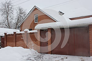 Wall and gates of residential house covered with snow