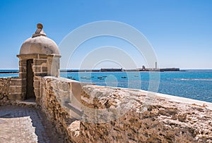 Wall and guardhouse at Santa Catarina fort with San Sabastian castle in the background on small island, CÃÂ¡diz SPAIN photo