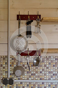 Wall with hanging old kitchen utensils