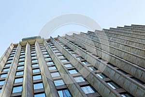 The wall of a highrise business building against a blue sky