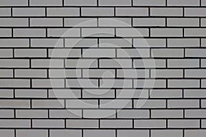 The wall of the house is lined with gray bricks. Used as a background.