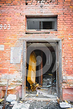 Wall of a house with peeling stucco and broken windows