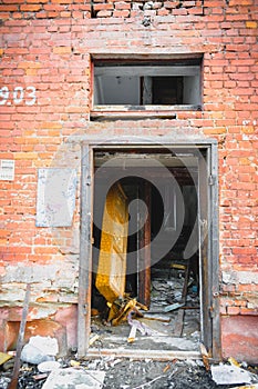 Wall of a house with peeling stucco and broken windows photo