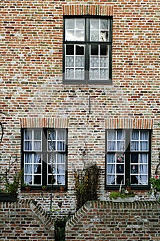 Wall of house from red brick with three windows