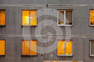 Wall with Iluminated windows of soviet era block apartment building.