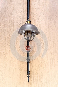 A wall lamp from a pipe with an edison lamp and a valve.