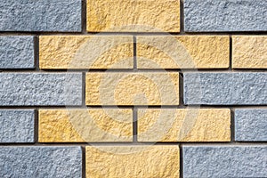 Wall of light grey and yellow colors stone blocks