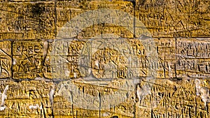 Wall with limestone bricks with illegible engravings that have been written by people with the passage of time