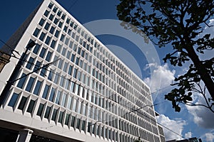 A wall with a lot of square glass windows on the building. The rhythm of the windows. Geometric pattern