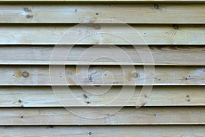 Wall made of brown wooden slats for background or texture .