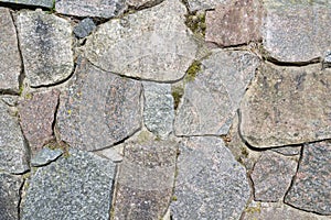 Wall made of large granite stones. Old stone wall. Natural material