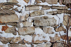 Wall made of natural rocks covered in snow