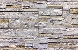 Wall of natural stone blocks of gray and sand color