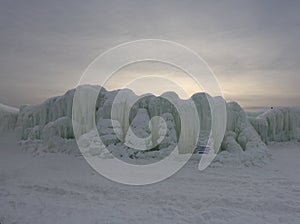 A wall made out of frozen water and icicles contrasted against the sunset at Ice Castles in Lake Geneva, Wisconsin