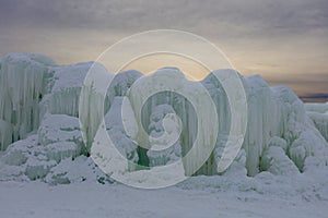 A wall made out of frozen water and icicles contrasted against the sunset at Ice Castles in Lake Geneva, Wisconsin