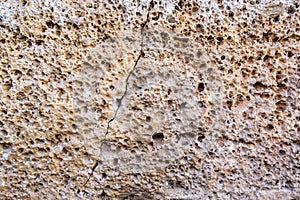 The wall is made of a Porous surface of Sandstone stone