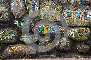 Wall made of rocks with colorful letters in nepalese in nepal