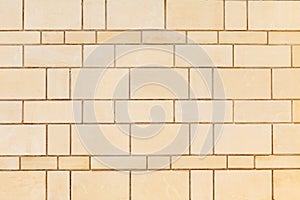 Wall made of smooth, rectangular yellow Sandstone blocks. Background image, texture photo