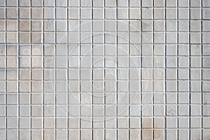 Wall made of square beige mosaic tiles