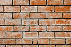 The wall of a modern building made of orange brick.