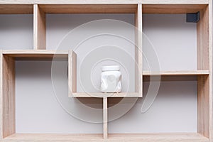 Wall mounted wood shelf with white ceramic vase