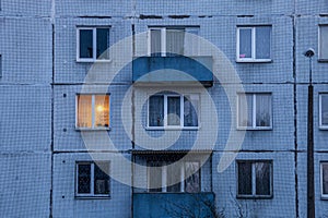 Wall of multi-storey residential building with Iluminated window.