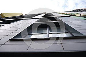 wall of office building made of metal plates with windows. Detail of modern residential building windows on ceramic