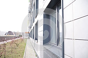 wall of office building made of metal plates with windows. Detail of modern residential building windows on ceramic