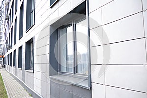 wall of office building made of metal plates with windows. Detail of modern residential building windows on ceramic