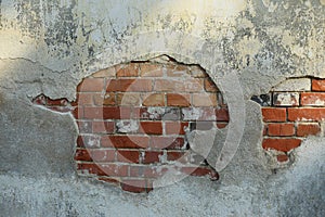 The wall of the old brick is partially covered with old plaster