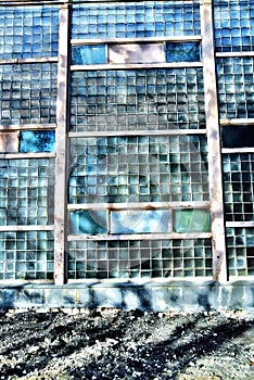 Wall of old building made of many glass pieces in the rays of the sun