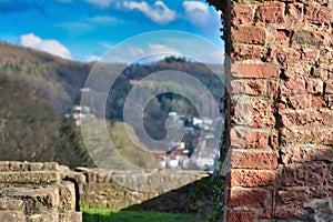 Wall of old castle ruin called `Hinterburg` in city Neckarsteinach in Germany with blurry `Odenwald` forest