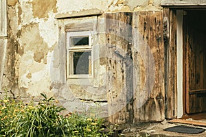 Wall of an old farm building. Natural texture. Specially preserved rural wooden house for agriturism, window, open door
