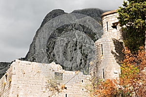 Wall of the old fortress against the background of the black mountain. Kotor, Montenegro